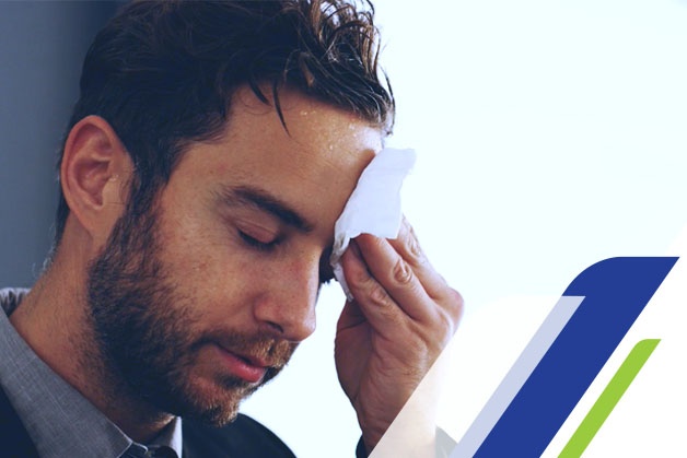 Homem secando o suor pensando em como acabar com o suor excessivo no corpo todo