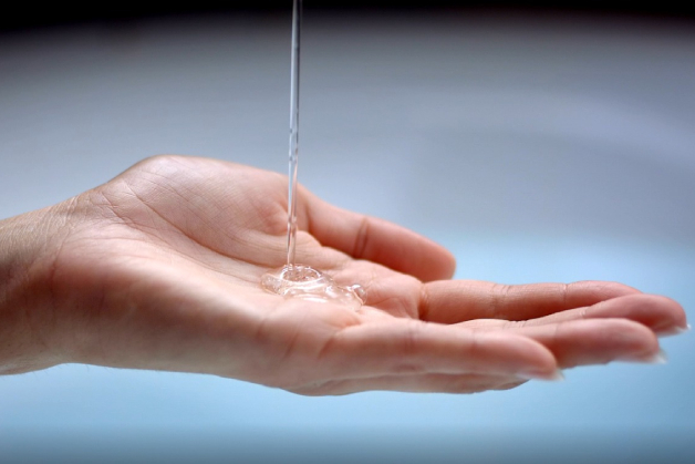 Mão com sabonete líquido transparente, simbolizando a importância do sabonete íntimo para a higiene íntima suave, segura e equilibrada.