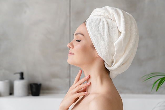 Mulher relaxando após o banho, com pele visivelmente hidratada, representando para que serve o óleo de linhaça: nutrir e suavizar a pele